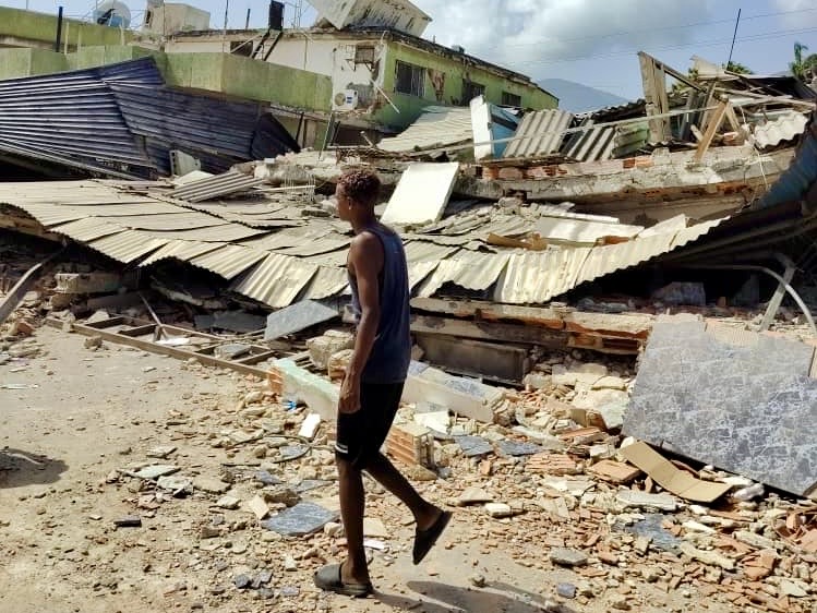 Joven caminando entre escombros tras el terremoto en Venezuela